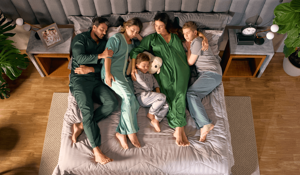 Família dormindo junta em uma cama confortável, ilustrando a importância de saber quantas horas de sono são necessárias para descansar bem