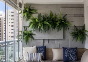 Samambaias suspensas em parede decorativa, ilustrando plantas para quarto que trazem frescor, leveza e aconchego ao ambiente