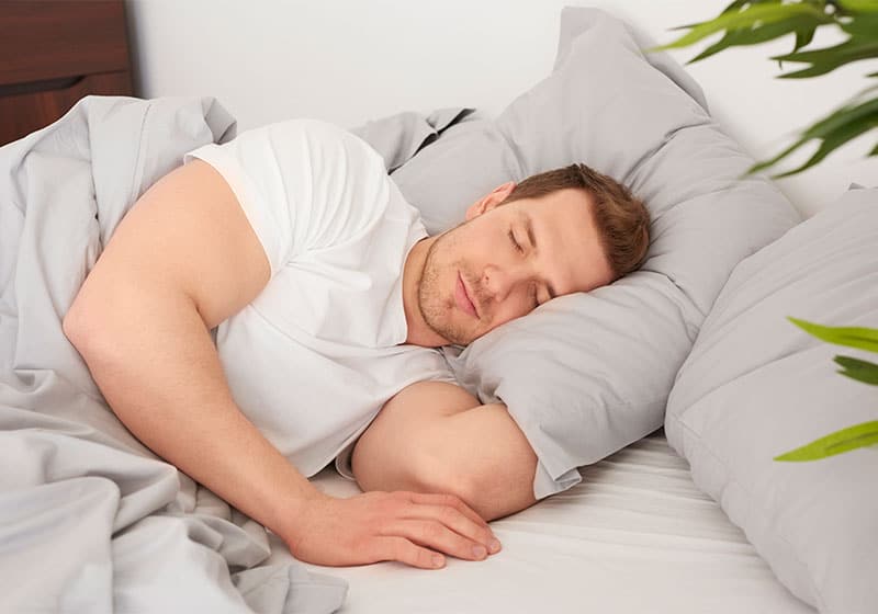 Homem dormindo tranquilamente com seu travesseiro de qualidade