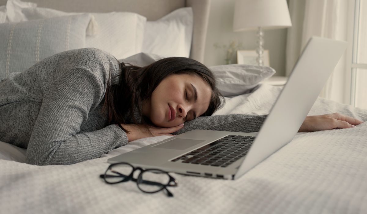 Mulher dormindo ao lado de notebook aberto, ilustrando o tema aprender dormindo e possivel e a relação entre sono, memória e aprendizado