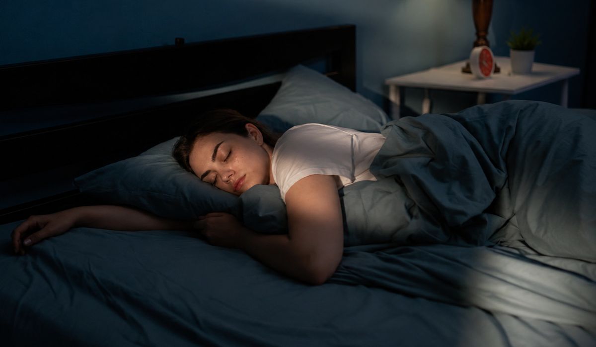 Mulher dormindo em quarto escuro e tranquilo, ilustrando dicas científicas para dormir melhor e melhorar a qualidade do sono.