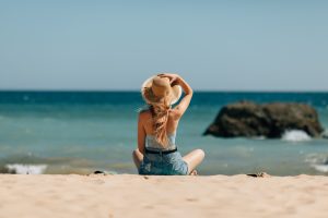 Mulher na praia olhando para o mar