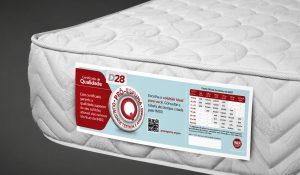 Colchão branco com etiqueta de certificação Pró-Espuma e selo INER, destacando qualidade testada e aprovada.