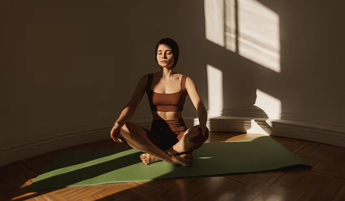Mulher praticando yoga em ambiente tranquilo, ilustrando como yoga melhora o sono por meio do relaxamento e da respiração