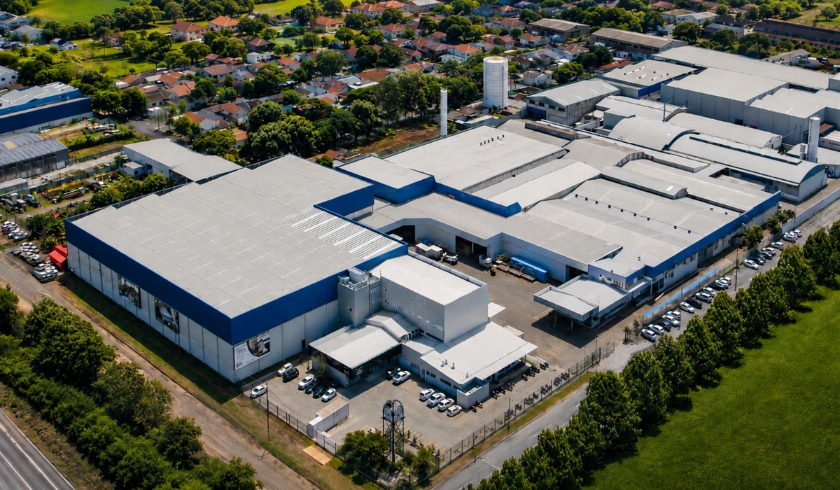 Vista aérea da fábrica da F.A. Colchões, destacando sua estrutura industrial em um conteúdo sobre purificação de gases e responsabilidade ambiental.
